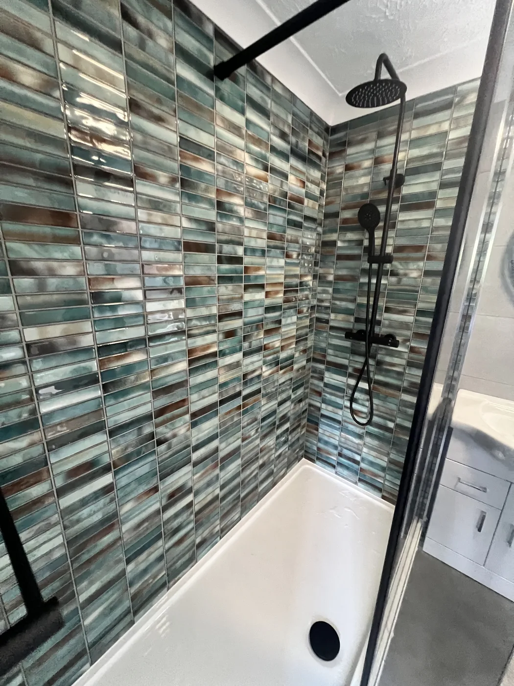 Statement teal tiled shower with matt-black fittings